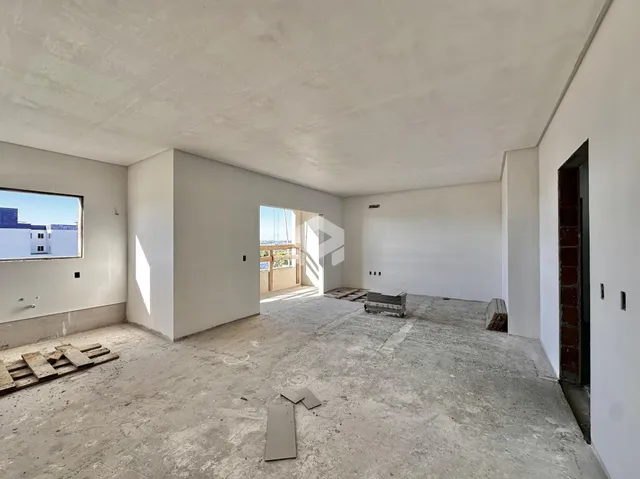 Interior de uma sala com piso de concreto em construção.
