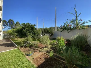 Vista externa de um jardim com gramado e cerca em Lajeado.