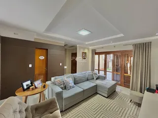 Sala de estar com sofá cinza e portas de madeira.