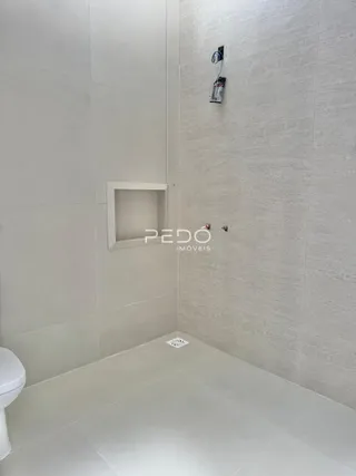 Interior de um banheiro com piso e paredes brancas.