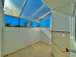 Interior de uma sala com teto de vidro e janelas amplas.