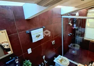 Foto de um banheiro com revestimento de cerâmica e box de vidro.