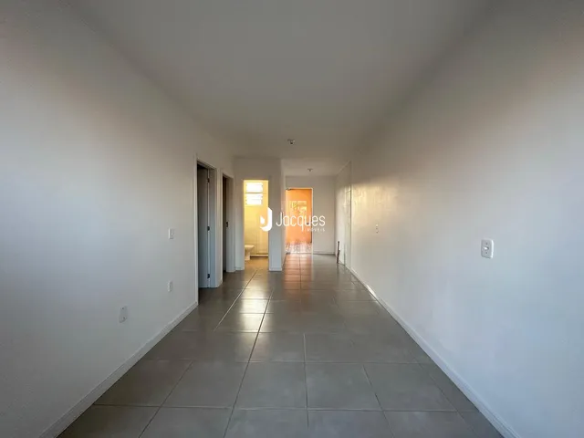 Corredor interno de uma residência com piso de cerâmica e paredes brancas.
