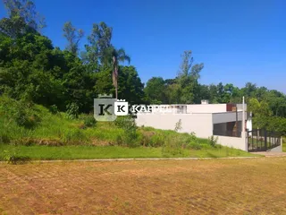 Fachada de uma residência com vegetação densa ao fundo.