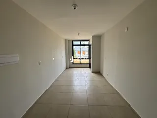 Corredor interno de uma residência com piso de cerâmica clara.