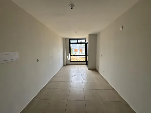 Corredor interno de uma residência com piso de cerâmica clara.