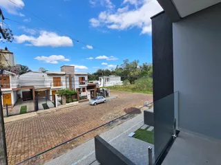 Vista externa de casas em Lajeado, Brasil, com área pavimentada.