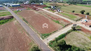 Imagem aérea de um terreno rural com campos agrícolas e estradas.