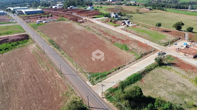 Imagem aérea de um terreno rural com campos agrícolas e estradas.