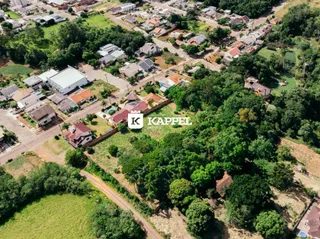 Vista aérea de uma área residencial em Lajeado, Brasil, mostrando casas e vegetação.