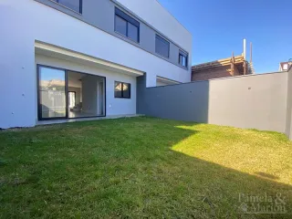 Fachada moderna de uma residência em Lajeado, Brasil, com jardim gramado em primeiro plano.