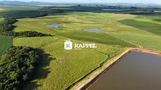 Vista aérea de uma propriedade rural com campos verdes e corpos d'água.