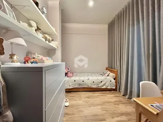 Quarto com cama e guarda-roupa em um ambiente claro.