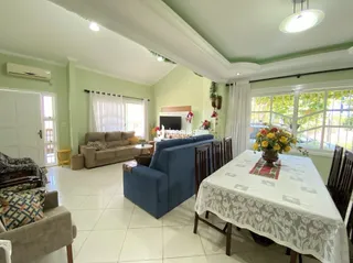 Sala de estar com sofá e janelas em uma residência.