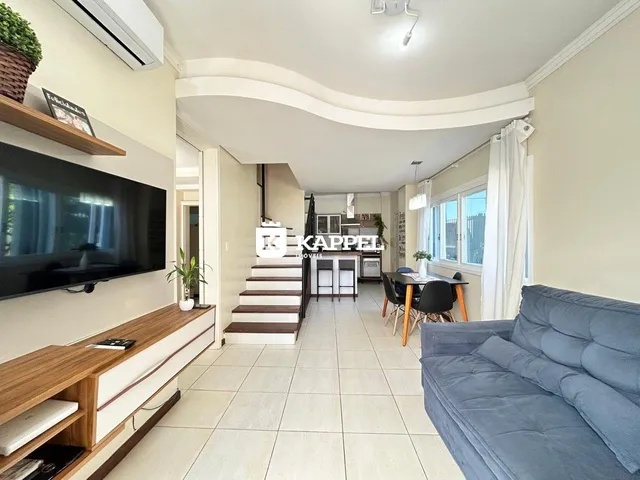Sala de estar com sofá, televisão e piso de cerâmica em um apartamento.