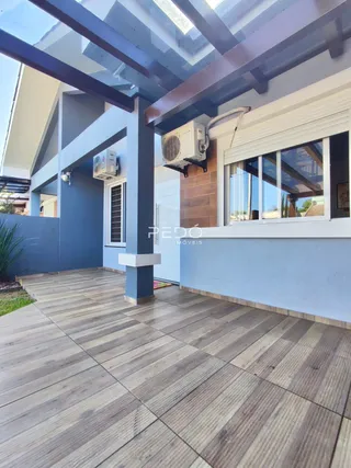 Fachada de uma casa moderna com deck de madeira no exterior.