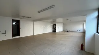 Ambiente interno amplo com piso de cerâmica e teto branco.