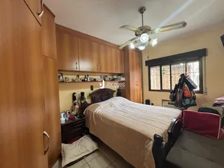 Quarto com armários de madeira e cama no interior de uma residência.