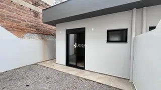 Fachada externa de uma residência com revestimento branco.