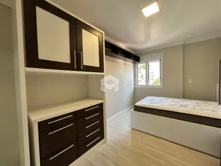 Quarto com cama e armário de madeira em um apartamento.