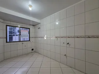 Interior de um corredor com paredes e piso de cerâmica branca.