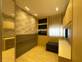 Quarto com paredes de tijolo e piso de madeira clara em um imóvel no Brasil.