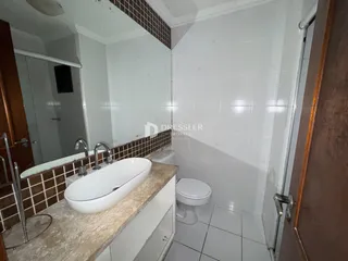 Foto de um banheiro com azulejos brancos e bancada de mármore.