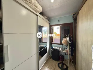 Foto de um quarto com armários brancos e piso de cerâmica.