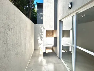 Vista de um corredor interno com parede texturizada e porta de vidro.