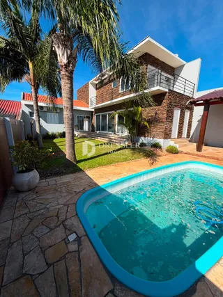 Fachada de uma residência com piscina e jardim em Lajeado, Brasil.
