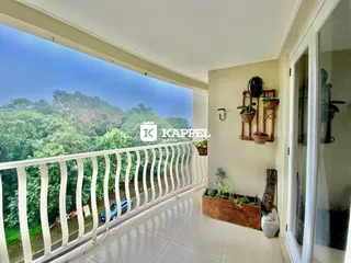 Vista ampla de uma varanda com paisagem verde exuberante.