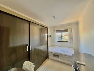 Quarto com armário embutido e piso de madeira clara.