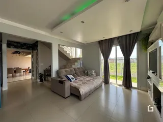 A sala de estar possui grandes portas de vidro que oferecem uma vista para o exterior.