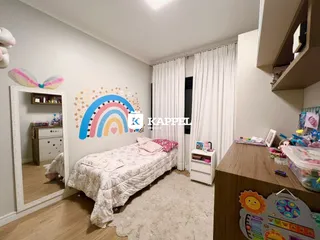 Quarto com cama e decoração de arco-íris em um apartamento.