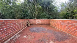 Vista de um pátio com muro de tijolos vermelhos no exterior.