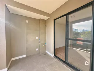 Hall de entrada com porta de vidro que dá acesso a uma área externa.