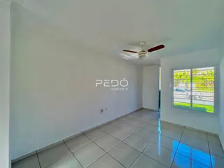 Ambiente interno de uma sala com piso de cerâmica e parede branca.