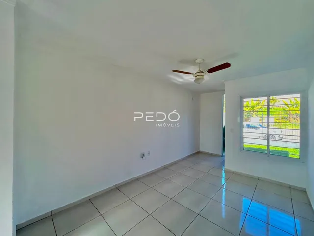 Ambiente interno de uma sala com piso de cerâmica e parede branca.