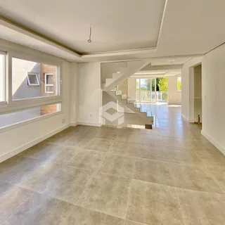 Sala de estar com piso de cerâmica clara e grande ambiente.