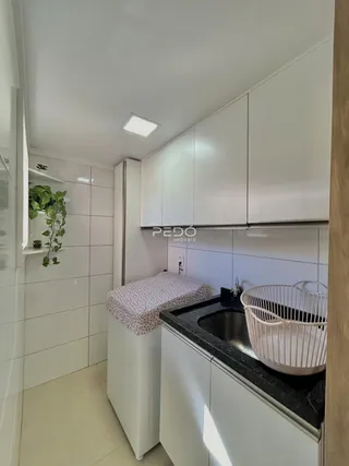 Foto de um ambiente interno com revestimento de azulejos brancos e armários brancos.