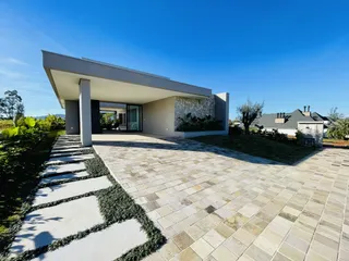 Fachada moderna de uma casa em Lajeado, Brasil, com área externa pavimentada.
