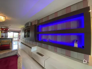 Ambiente interno de uma sala com estantes de destaque iluminadas.