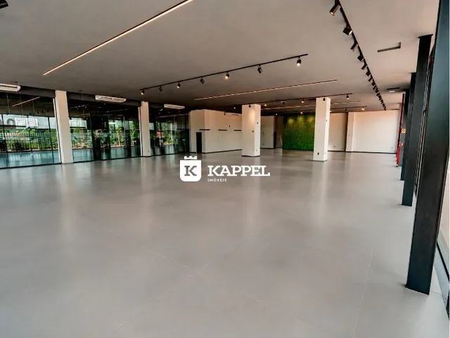 Ambiente interno amplo com piso claro e iluminação moderna em um imóvel.