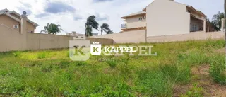 Área externa com grama e vegetação em frente à residência.