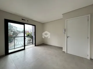 Ambiente interno de uma sala com porta de vidro voltada para a rua.