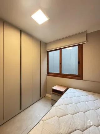 Quarto com cama e janela em uma residência.