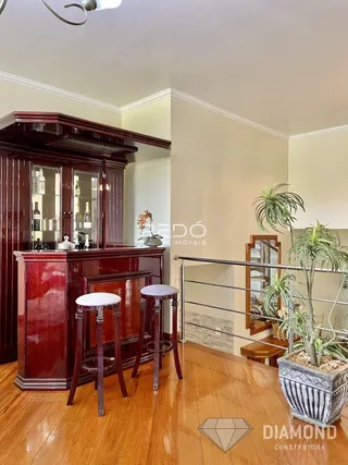 Interior de uma sala com piso de madeira e móveis de madeira escura.
