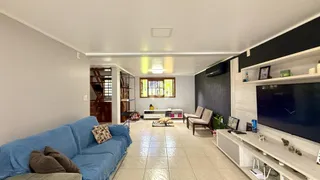 Sala de estar com sofá azul e piso de cerâmica clara.