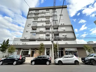 Fachada de um prédio residencial em Lajeado, Brasil, com apartamentos e estacionamento na frente.