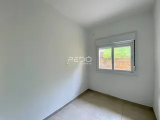 Ambiente interno de uma sala com piso de cerâmica e janela em um imóvel.